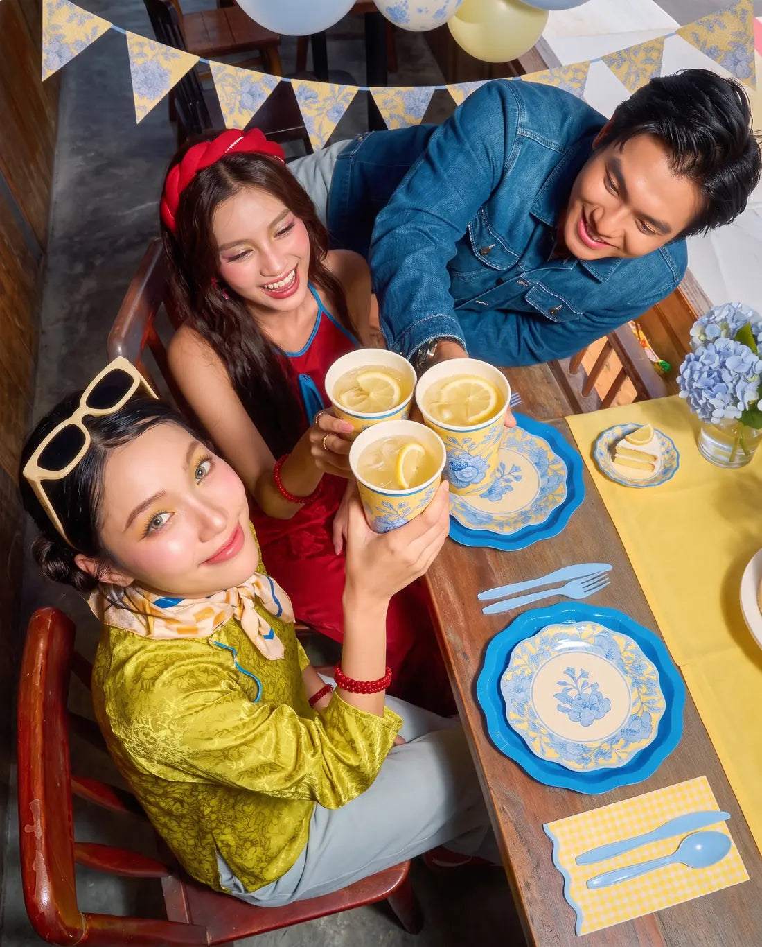 Friends toasting over a table set with blue floral plates