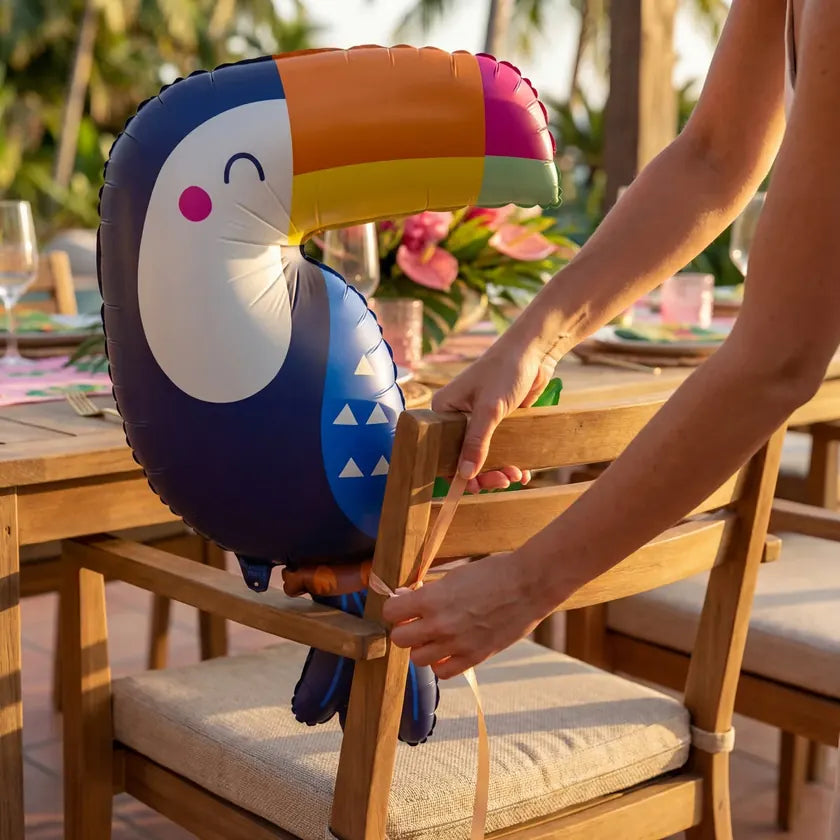 Adding the finishing touches to a colorful Tropical Paradise party table